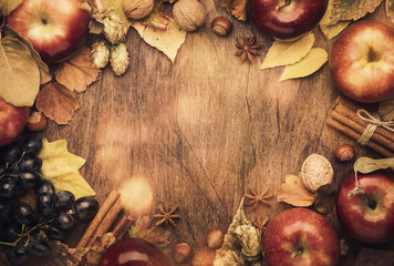 Autumn food background. Ripe apples with nuts, fallen leaves and cinnamon on rustic wooden table. Top view. Copy space