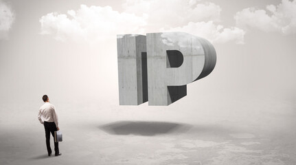 Fototapeta premium Rear view of a businessman standing in front of IP abbreviation, modern technology concept