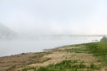 mountain river bank in the morning fog