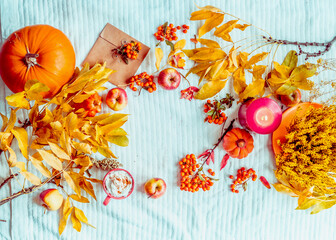 Fall mood with various autumn decoration: Pumpkin, cup of hot chocolate, candle on blue knitted...