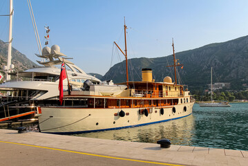 Fototapeta premium An old yacht moored at the harbour at the Old Town of Kotor, at the bay of Kotor