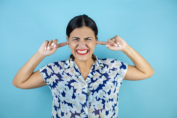 Beautiful woman over isolated background covering ears with fingers with annoyed expression for the noise of loud music. Deaf concept.