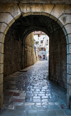 Fototapeta na wymiar An alley way in the old town of Kotor, with flying brooms in the background
