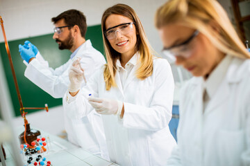 Group of young researchers analyzing chemical data in the laboratory