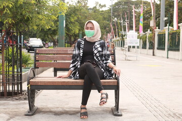 Obraz na płótnie Canvas Asian woman who is on vacation in the city of Yogyakarta wears a mask. New normal travel after covid-19 pandemic concept