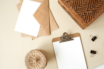 Clipboard tablet pad with blank paper sheet on beige table. Artist home office desk workspace with...