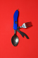 Travel kit for tourism opener spoon and fork on a red background with space for text