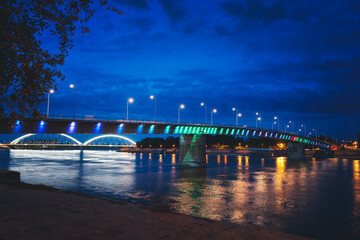 Fototapeta na wymiar Rainbow bridge by night on Danube river between the Petrovaradin and city of Novi Sad in Serbia at night