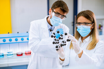 Young chemists holds molecular model in the lab