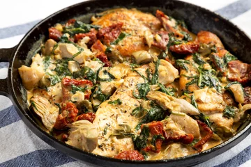 Fotobehang Homemade Creamy Tuscan Chicken in a cast iron pan, side view. Close-up. © Liudmyla