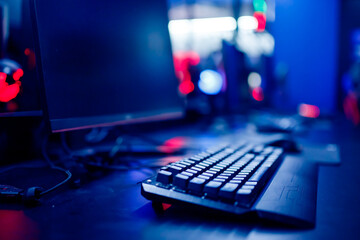 Professional cyber video gamer studio room with personal computer armchair, keyboard for stream in neon color blur background. Soft focus © Parilov