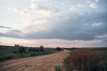 Fototapeta na wymiar landscape ground road in countryside late summer evening with cloud sky