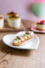 Traditional French dessert eclair on a heart-shaped plate.