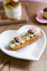 Traditional French dessert eclair on a heart-shaped plate.