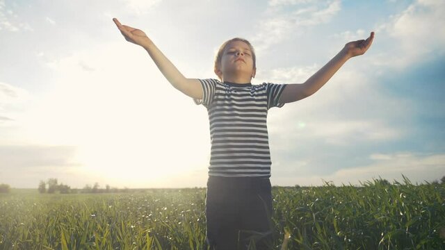boy prays pulls hands to the sky against a blue sky. child concept faith religion and happy family. kid son hands to the side against the blue lifestyle sky jew praying to god. worship and gratitude