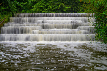 White Water flowing over weir low-level view at long exposure for blurred water effects and textures 