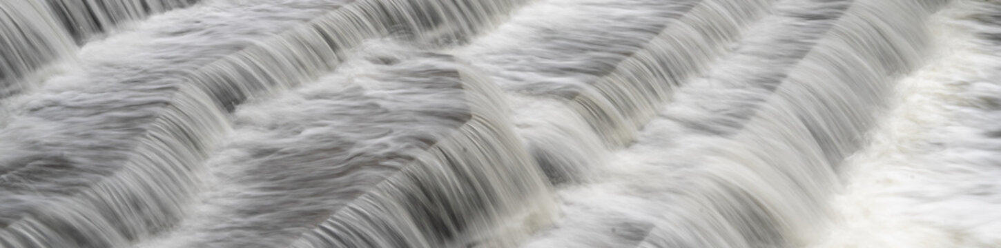 White Water flowing over weir low-level view at long exposure for blurred water effects and textures 