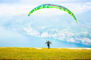 Gleitschirmfliegen am Gardasee mit Bergpanorama im Hintergrund See Paragleiter Italien Sport Berg / Paragliding at Garda lake in Italy Mountains Alps Paragliter 