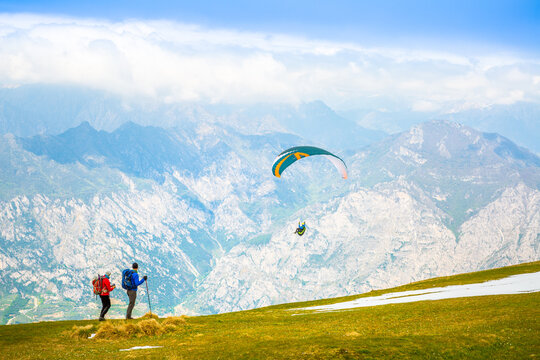 Gleitschirmfliegen am Gardasee mit Bergpanorama im Hintergrund See Paragleiter Italien Sport Berg / Paragliding at Garda lake in Italy Mountains Alps Paragliter 