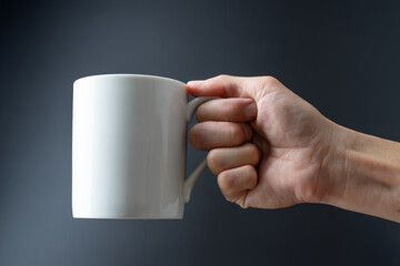 hand holding cup on black