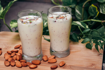 Healthy Almond milk shake in glass with almonds on table.