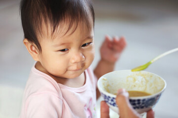 A happy baby girl sitting and eating