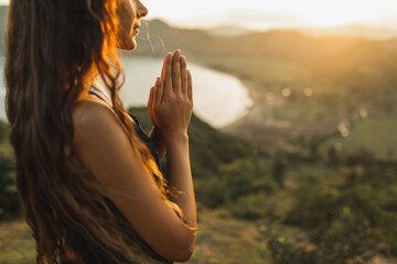 Woman praying alone at sunrise. Nature background. Spiritual and emotional concept. Sensitivity to nature - 374655669