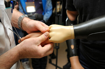 Doctor hands helping disabled man to try an artificial limbs on