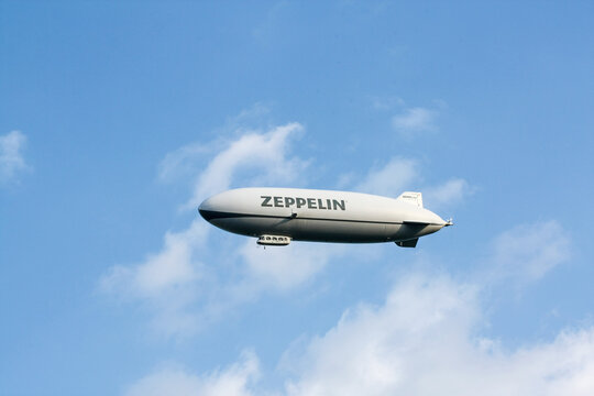 Airship, zeppelin flying in the blue sky with white clouds. Zeppllin airships often offer tourist passagers for leisure flights.