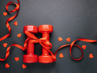 Red dumbbells wrapped in red ribbon as a gift for Valentine's Day.