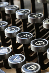 Extreme close up image of vintage azerty typewriter keys, with the letter F centered. Selective focus.