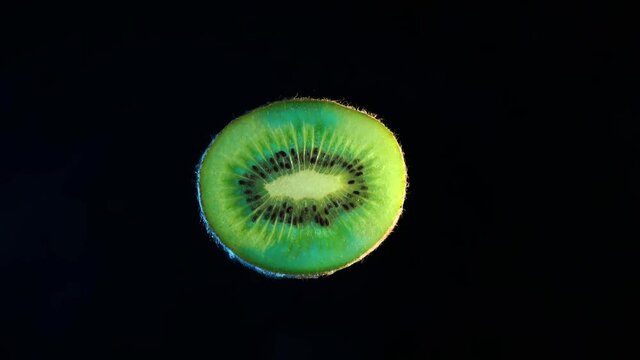 4k. Crushed piece of kiwi fruit on a black background