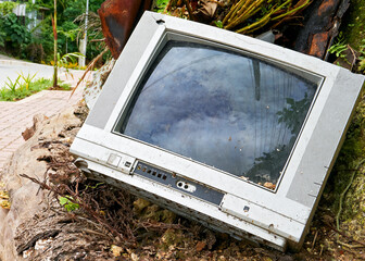 Old,  broken analog television set dumped along the roadside by an irresponsible consumer in Asia 