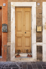 Old vintage wooden front door in an italian city. 30 August 2020, Rome, Italy 