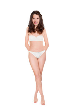 Full length portrait of an attractive cheerful woman wearing bra and panties, studio photo isolated in front of white background