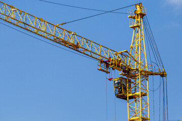 Construction site background. Hoisting cranes and new multi-storey buildings. I.ndustrial background.Building construction site work against blue sky