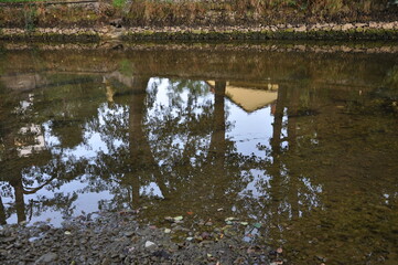 Calm mirroring river with trees reflected on water surface