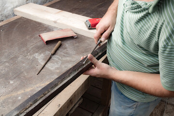 Male carpenter working on old wood in a retro vintage style.
