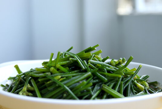 Close up atir fried  Chinese chives flowers or Allum tuberosum on white dish and blur background.