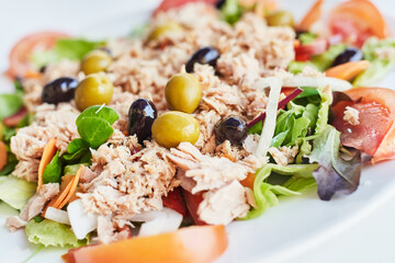 Fresh salad with tuna, olives, tomatoes, onions and carrots