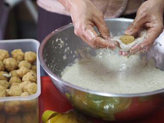 Fototapeta premium Woman doing Stuffed Dough Pyramid Dessert, Stuffed Dough Pyramid, year cake, Chinese New Year’s cake, dessert Made with glutinous rice flour and sugar put banana leave small basket and steamed cooked