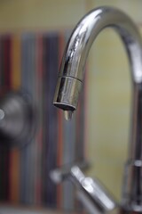 The crane is leaking. a drop of water drains from the tap. leaking plumbing.