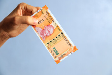 the hand holds 200 rupees bill