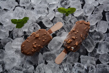 Popsicle chocolate ice cream with almonds on ice cubes background