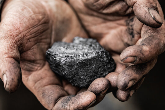 Closeup Miner holds coal palm. Concept mining, Top view