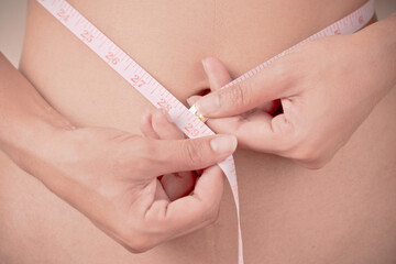 women Slim waist with a tape measure around it