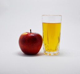 one red apple and a glass of apple juice on a white background
