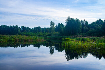 Obraz na płótnie Canvas Morning sunrise with blue sky on a forest lake
