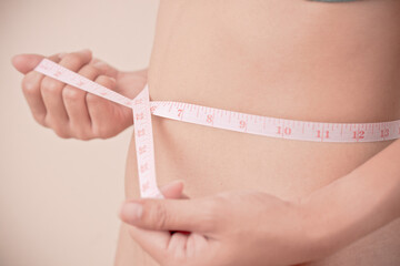women Slim waist with a tape measure around it