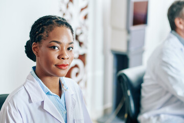 Fototapeta na wymiar Portrait of serious young Black female doctor in labcoat looking at camera
